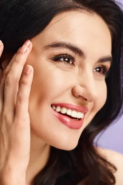 Uma mulher com um sorriso radiante adiciona os toques finais à sua rotina de maquiagem. — Fotografia de Stock