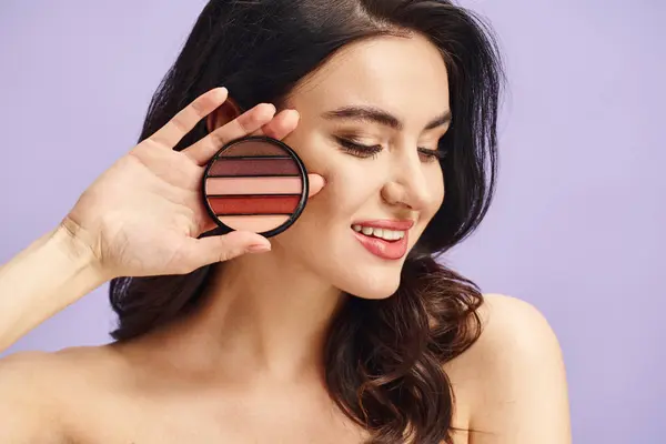 Attractive woman with natural beauty holds a palette and applies makeup. — Stock Photo