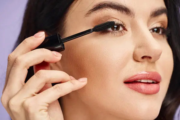 Une femme avec une beauté naturelle appliquant délicatement le mascara pour améliorer ses caractéristiques. — Photo de stock