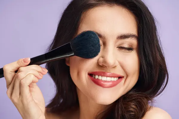 A woman enhancing her natural beauty with makeup application. — Stock Photo