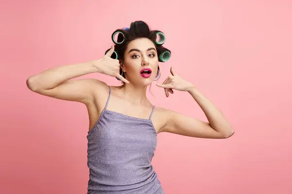 A woman with curlers in her hair, enhancing her natural beauty with makeup. — Stock Photo