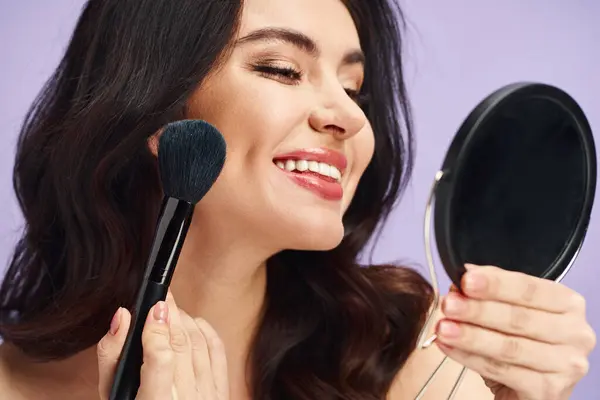 Uma mulher com beleza natural segurando uma escova de maquiagem na frente de um espelho. — Fotografia de Stock