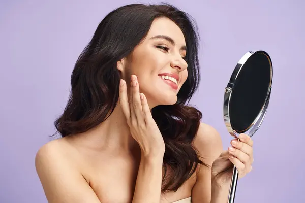 A woman gazes at herself in the mirror, applying makeup. — Stock Photo