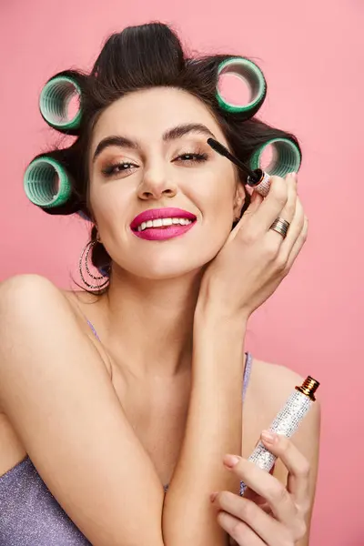 Woman with curlers in hair holds maskara. — Stock Photo