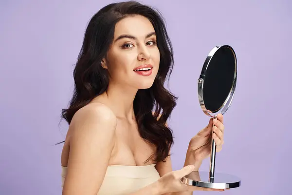 A woman in a strapless dress holding a mirror. — Stock Photo