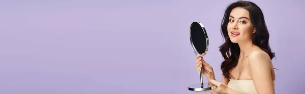 Woman in white dress applies makeup, holding mirror. — Stock Photo