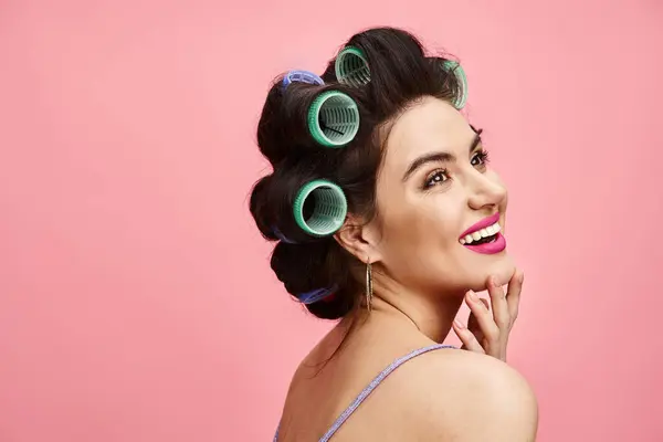 A woman with curlers in her hair striking a pose for a camera. — Stock Photo