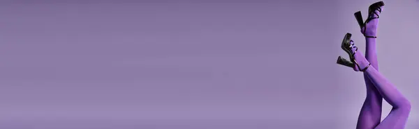 A young woman in vibrant purple tights against a backdrop in a studio. — Stock Photo