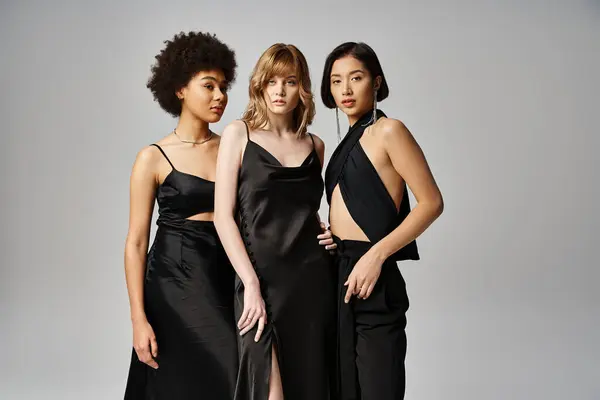 Eine Gruppe schöner Frauen unterschiedlichster Herkunft steht in eleganter Frühlingskleidung vor grauem Studiohintergrund zusammen.. — Stockfoto