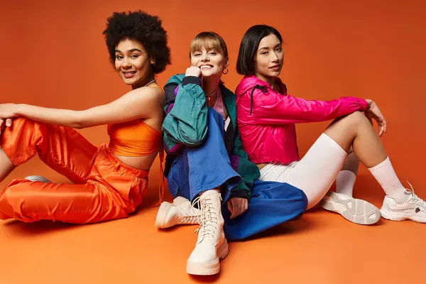Trois femmes d'ethnies différentes posant joyeusement ensemble sur le sol pour un moment ludique au printemps. — Photo de stock