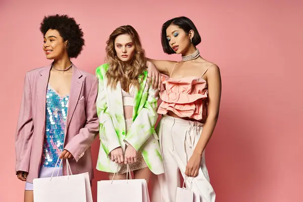 A group of beautiful women holding shopping bags, showcasing diversity with Caucasian, Asian, and African American ladies on a pink background. — Stock Photo