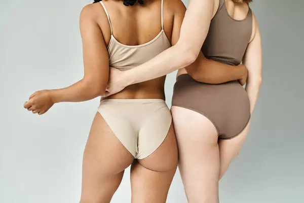 Two beautiful diverse women in cozy pastel underwear standing side by side. — Stock Photo