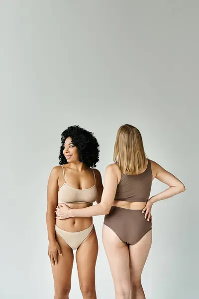 Duas mulheres bonitas em roupa interior pastel aconchegante em pé ao lado um do outro. — Fotografia de Stock