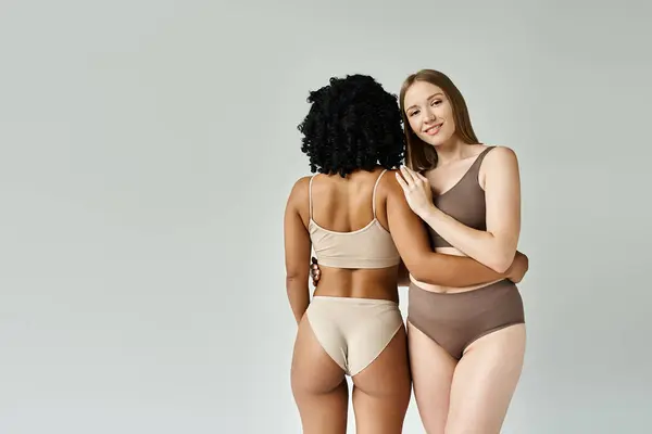 Two diverse women stand side by side in pastel underwear. — Stock Photo