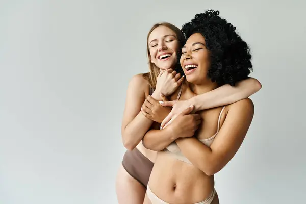 Deux femmes, portant des sous-vêtements pastel confortables, s'embrassent tendrement. — Photo de stock