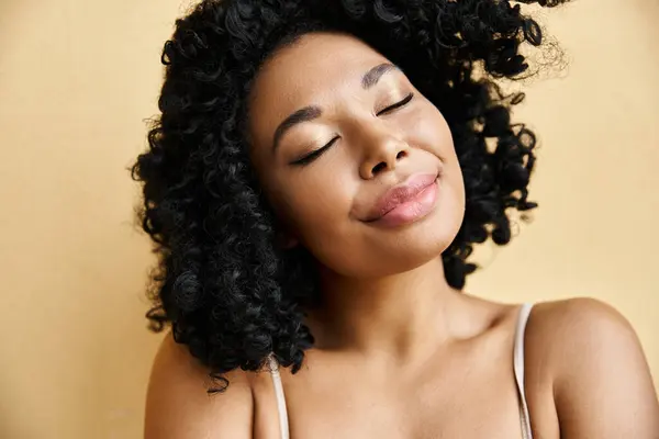 Close-up de uma mulher bonita com cabelo encaracolado em roupa interior pastel aconchegante. — Fotografia de Stock