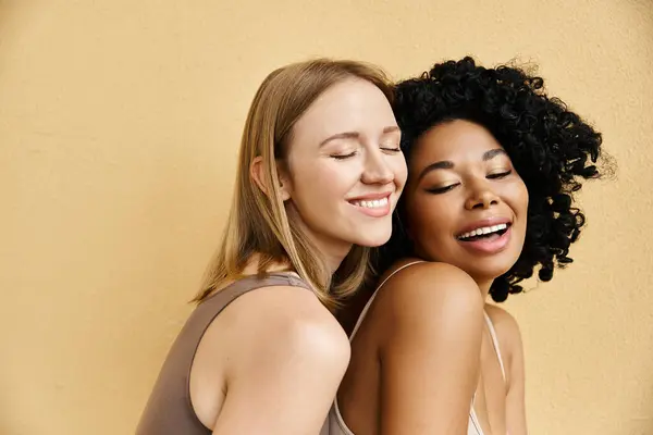 Two beautiful women in pastel underwear hugging with closed eyes in a tender moment. — Stock Photo