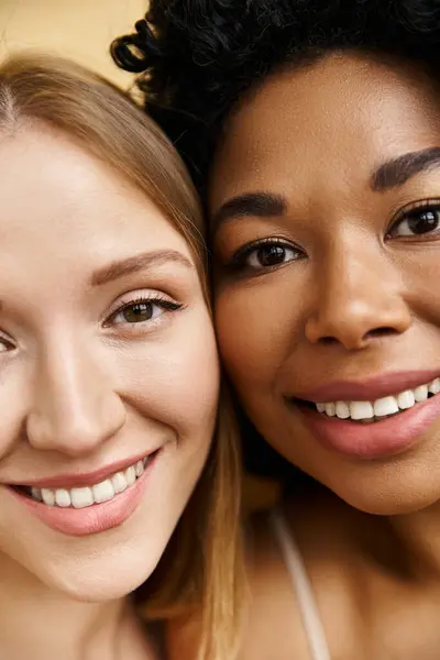 Дві красиві різноманітні жінки в затишній пастельній білизні посміхаються і позують на картину. — стокове фото