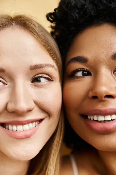 Дві різні жінки посміхаються і позують у затишній пастельній білизні. — стокове фото