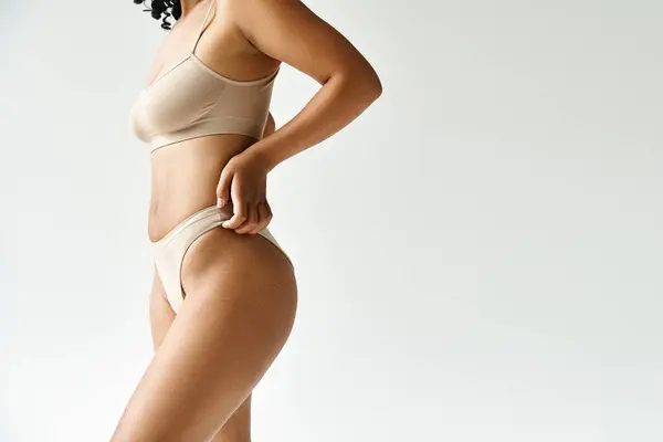A beautiful diverse woman in a tan bikini striking a pose for the camera. — Stock Photo