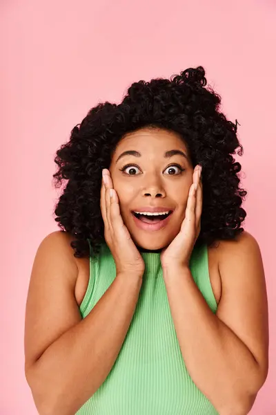 Woman in a green shirt posing with hands on face. — Stock Photo