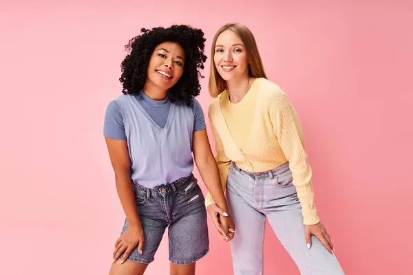 Deux femmes élégantes debout élégamment sur un fond rose. — Photo de stock