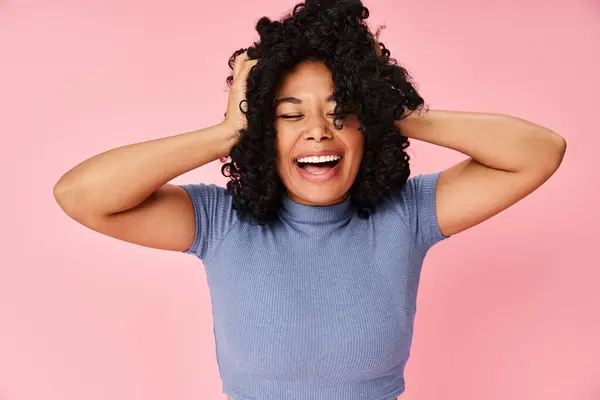 A woman with casual attire holding her hair in front of her face. — Stock Photo
