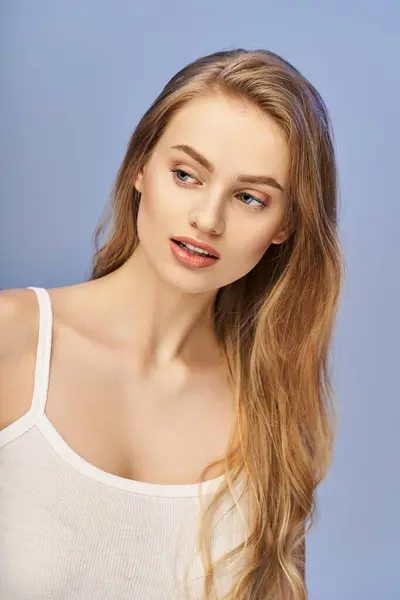 Una joven rubia con el pelo largo emana tranquilidad en una camiseta blanca. - foto de stock