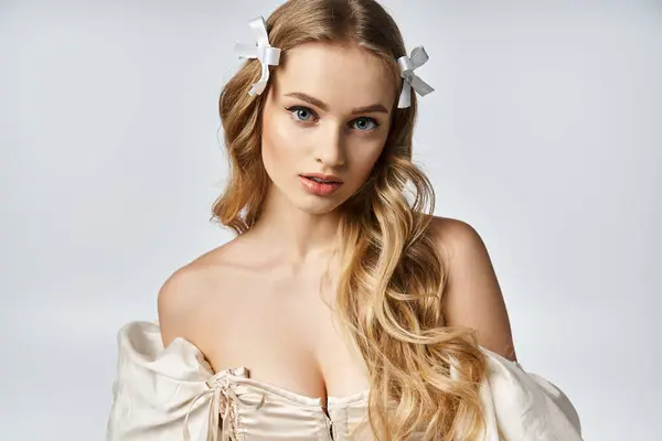 A young, blonde woman exudes elegance in a flowing white dress, her long hair cascading down. — Stock Photo