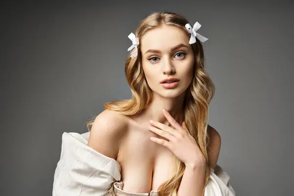 Uma jovem e bela mulher loira elegantemente posa em um vestido branco, exalando graça e feminilidade. — Fotografia de Stock