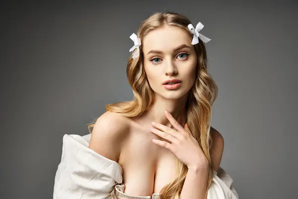 A young and beautiful blonde woman elegantly poses in a white dress, exuding grace and femininity. — Stock Photo