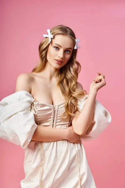 Молода блондинка виявляє грацію і красу, позує в білій сукні в студійній обстановці. — стокове фото