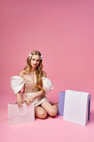 Una giovane, bella donna bionda seduta a terra circondata da borse della spesa. — Foto stock