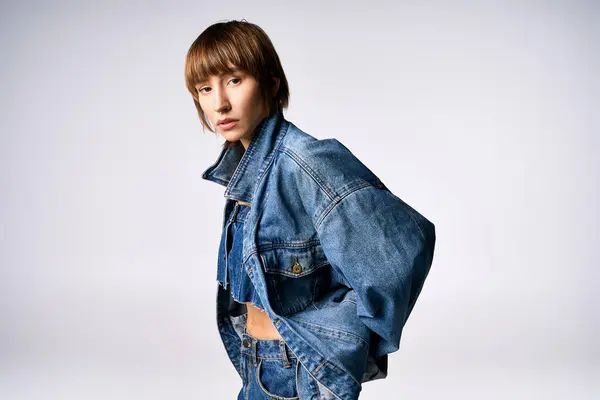 Una joven de moda con el pelo corto posa con confianza para un retrato en un estudio, exudando vibraciones urbanas chic. - foto de stock