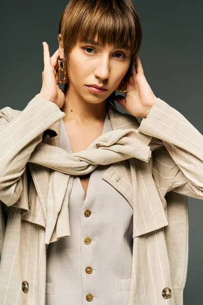 Una giovane donna in un ambiente studio indossa una sciarpa elegante intorno al collo, trasudando grazia e bellezza. — Foto stock