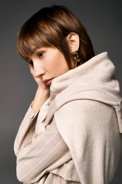 Uma jovem mulher com cabelo curto elegantemente vestindo um lenço ao redor do pescoço em um ambiente de estúdio. — Fotografia de Stock