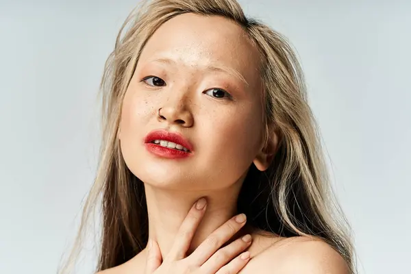 A captivating asian woman with long hair and red lipstick strikes a pose. — Stock Photo