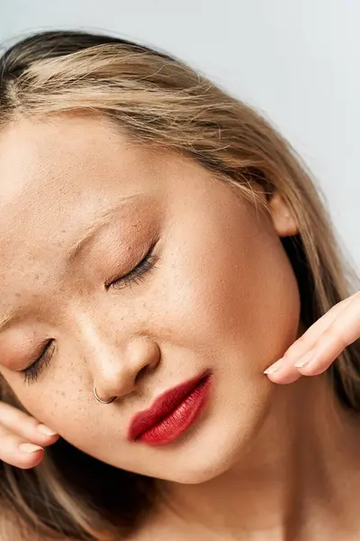 Азіатська жінка безтурботний із закритими очима, торкаючись голови. — стокове фото