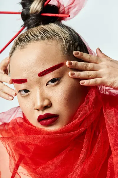 Asiatin, Hände auf dem Kopf, in rotem Kleid, anmutig balanciert. — Stockfoto