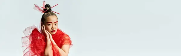 A vibrant Asian woman in a striking red dress posing with red veil. — Stock Photo