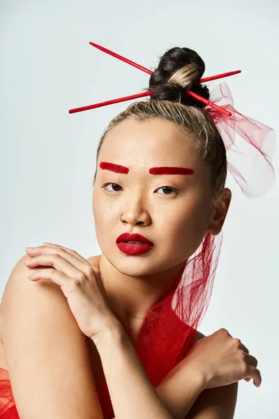 Asian woman in vibrant red makeup and a veil poses artistically. — Stock Photo