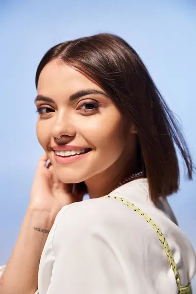 Uma jovem mulher com cabelo morena exala felicidade enquanto sorri calorosamente em um estúdio. — Fotografia de Stock