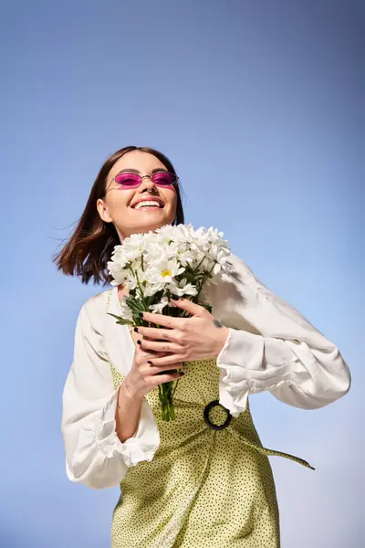 Uma jovem com cabelo morena, elegantemente segurando um buquê de flores em um estúdio. — Fotografia de Stock