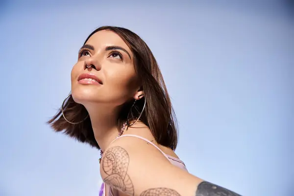 A young woman with brunette hair displaying a striking tattoo on her arm, embodying creativity and individuality. — Stock Photo