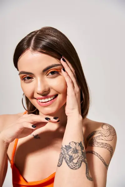 Молодая женщина с брюнетками гордо показывает свою татуировку на руке в студии. — стоковое фото
