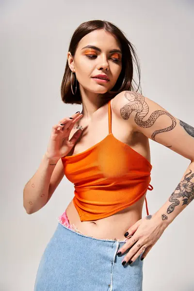 Молодая женщина с брюнетками, с гордостью демонстрирующая поразительную татуировку на руке в творческой студии. — стоковое фото