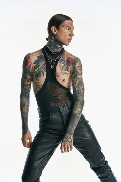 Um jovem exibindo tatuagens intrincadas e vários piercings em seu peito, exalando um senso de auto-expressão e arte. — Fotografia de Stock