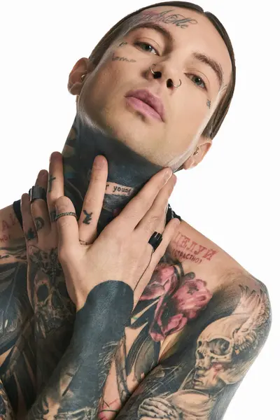 Молодий стильний чоловік з безліччю хитромудрих татуювань, що обожнюють його тіло, демонструє своє унікальне відчуття артистизму та самовираження. — стокове фото