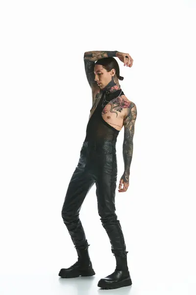 A stylish young man with tattoos stands confidently against a white background. — Stock Photo