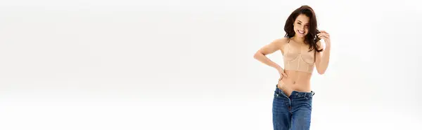 Una giovane donna con un top abbronzante colpisce una posa accattivante per la fotocamera. — Foto stock